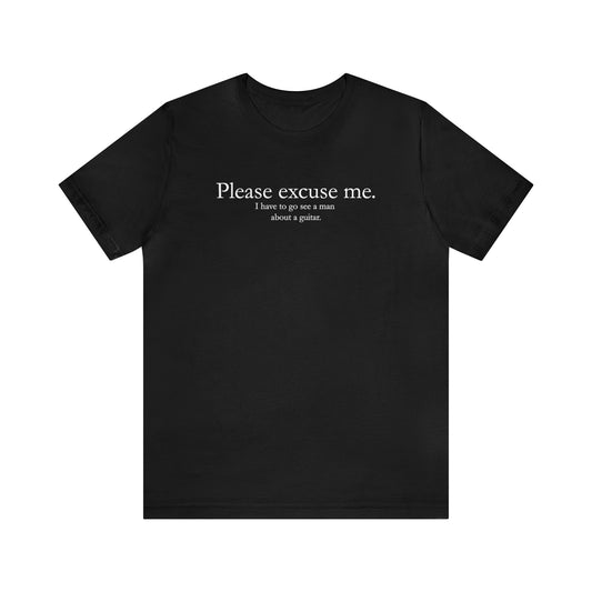 A graphic muisc t-shirt with the words "Please Excuse me.  I have to go see a man about a guitar." Black shirt.