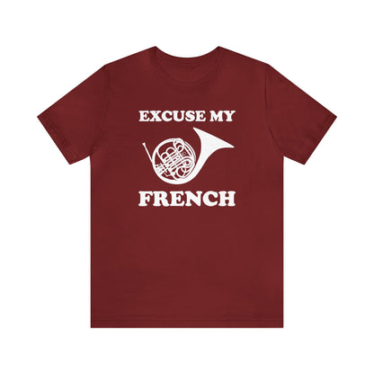 A music pun t-shirt with the phrase "excuse my French" and a simple graphic of a french horn.  Text and graphic are black, t-shirt color is red.