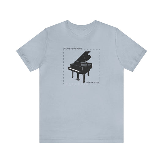 Graphic music t-shirt.  A grand piano and the words "Pictured Below: Piano" followed by the text "Not actual size."  Light blue shirt.